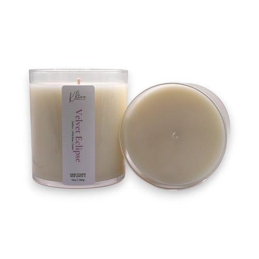Klima Candle Co. Velvet Eclipse candle in a clear glass jar with a pale cream wax. Scent notes include saffron, rose, and cashmere musk.