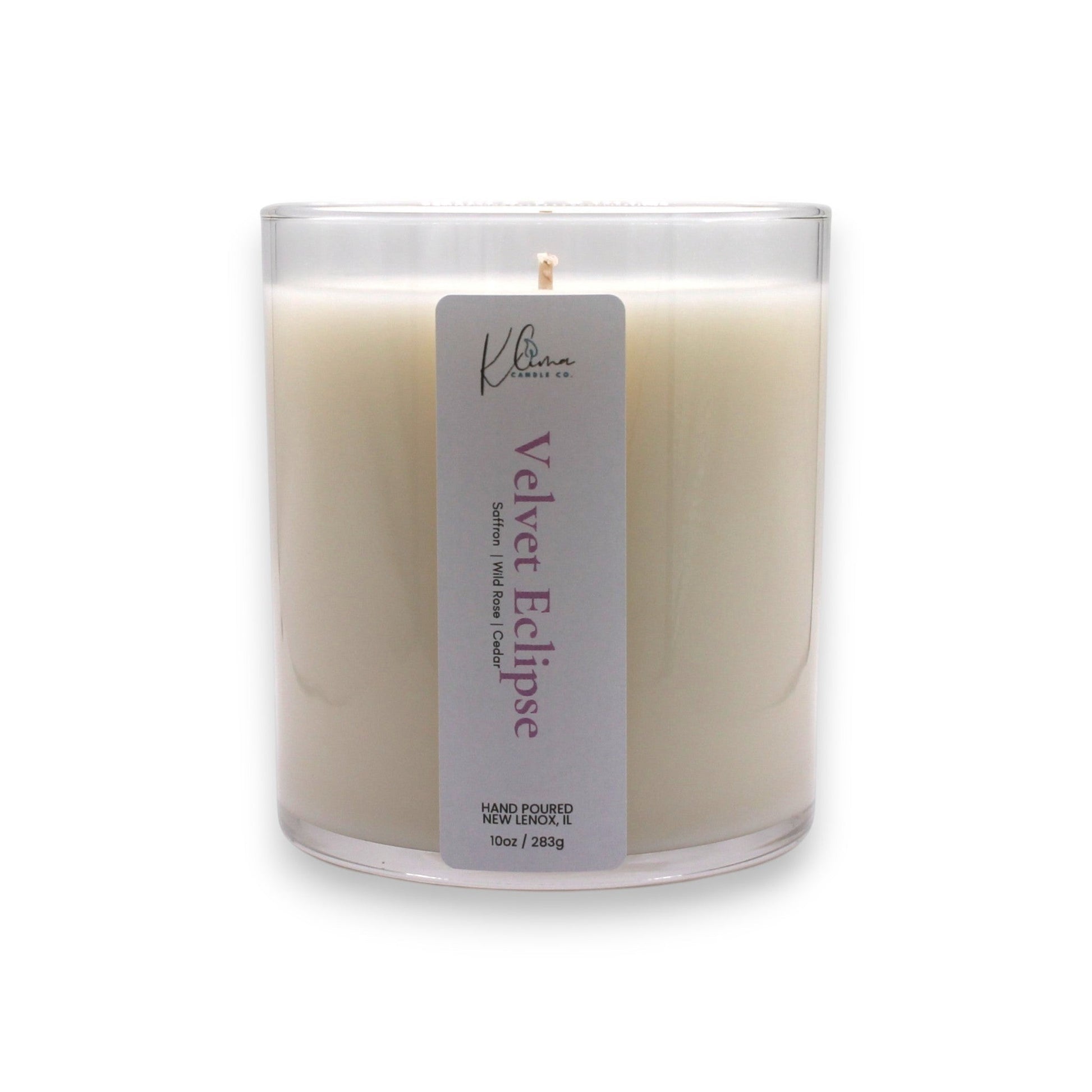 Klima Candle Co. Velvet Eclipse candle in a clear glass jar with a light cream wax. Scent notes: Saffron, Rose, Cashmere Musk.